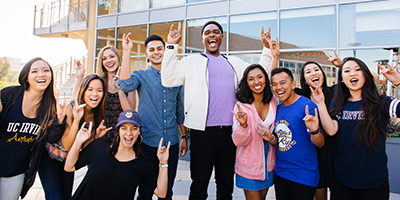 UCI students making the ZOT hand signs